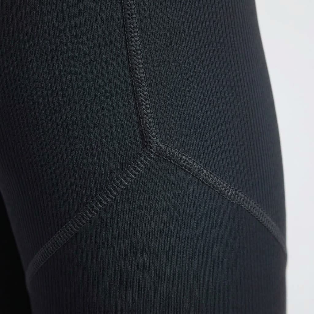 Close-up of the fine rib knit and Y-shaped flat-lock seam on the matte black crossover waist leggings